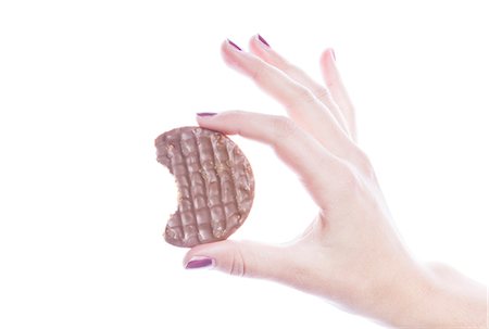 Detail shot of woman holding cookie over white background Foto de stock - Royalty Free Premium, Número: 693-06497612