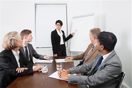 diverse group of business people - Young woman using whiteboard in business meeting Stock Photo - Premium Royalty-Free, Code: 693-06497669