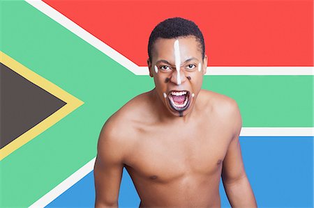 enérgico - Portrait of aggressive mixed race man against South African flag Foto de stock - Sin royalties Premium, Código: 693-06497750