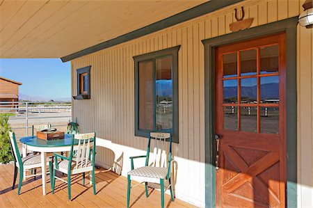 ferradura - Ranch porch overlooking horse stables Foto de stock - Royalty Free Premium, Número: 693-06667893