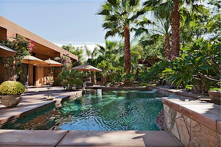 swimming pool and backyard - Luxury Villa with waterfall feature and palm trees Stock Photo - Premium Royalty-Free, Code: 693-06667950