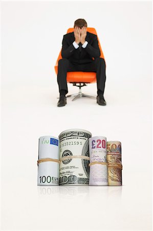 Money rolls with worried businessman on chair representing financial problems Photographie de stock - Premium Libres de Droits, Code: 693-06667989