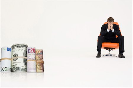 Money rolls with worried businessman on chair representing financial problems Foto de stock - Sin royalties Premium, Código: 693-06667996