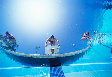 Low angle view of female swimmers ready to dive in pool from starting position Foto de stock - Sin royalties Premium, Código: 693-06668085