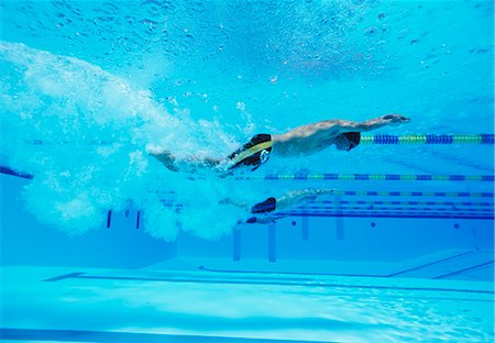 sports and swimming - Underwater shot of three male athletes racing in swimming pool Stock Photo - Premium Royalty-Free, Code: 693-06668106