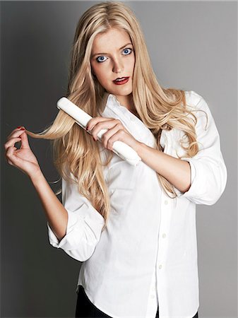 simsearch:693-06967285,k - Pretty blonde girl with hair straightener Stock Photo - Premium Royalty-Free, Code: 693-06967295