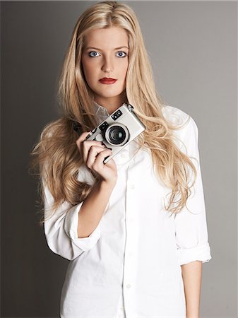 elegant young lady - Pretty blonde girl holding camera Stock Photo - Premium Royalty-Free, Code: 693-06967293