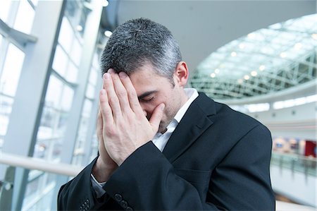 Disappointed businessman with head in hands Stock Photo - Premium Royalty-Free, Code: 693-06967322