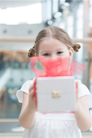 delighted gift not christmas - Young girl handing present towards camera Stock Photo - Premium Royalty-Free, Code: 693-06967377