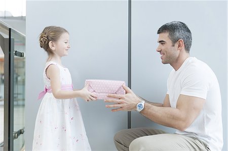 family shopping mall - Young girl handing present to her father Stock Photo - Premium Royalty-Free, Code: 693-06967387