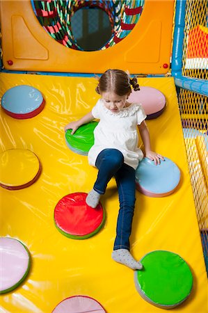 simsearch:693-06967402,k - Young girl climbing down ramp in soft play centre Photographie de stock - Premium Libres de Droits, Code: 693-06967394