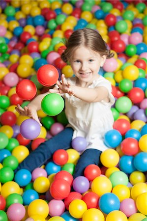 simsearch:693-06967402,k - Young girl in ball pit throwing colored balls Photographie de stock - Premium Libres de Droits, Code: 693-06967390