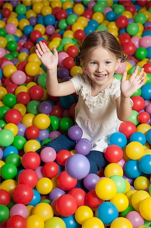 simsearch:693-06967402,k - Young girl in ball pit throwing colored balls Photographie de stock - Premium Libres de Droits, Code: 693-06967391