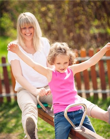 Mother and daughter ride seesaw together Stock Photo - Premium Royalty-Free, Code: 693-06967459