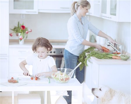 dog with people - Mother and Daughter (8-9) preparing healthy meal in kitchen Foto de stock - Sin royalties Premium, Código: 693-06967471