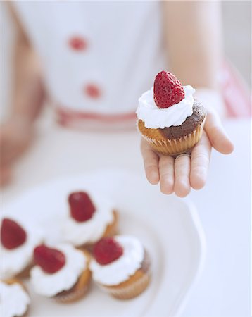 people eating baked goods - Young girl holding cup cake Stock Photo - Premium Royalty-Free, Code: 693-06967497