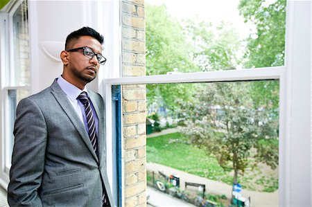 eyeglasses for indian men - Portrait of Indian Businessman wearing glasses standing by the window Stock Photo - Premium Royalty-Free, Code: 693-06967507