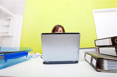 Womans head poking out over top of laptop Stock Photo - Premium Royalty-Free, Code: 693-06967509