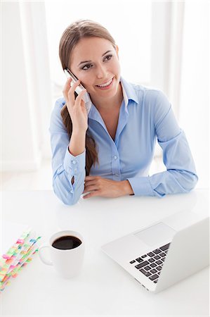 pictures of people seating on a table - Woman using cell phone Stock Photo - Premium Royalty-Free, Code: 693-07444414