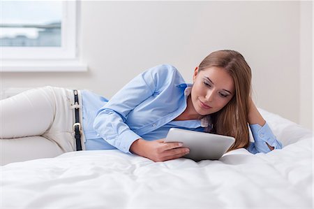 solemne - Beautiful woman using tablet computer on her bed Foto de stock - Sin royalties Premium, Código: 693-07444426