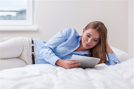 solemne - Beautiful woman using tablet computer on her bed Foto de stock - Sin royalties Premium, Código: 693-07444426