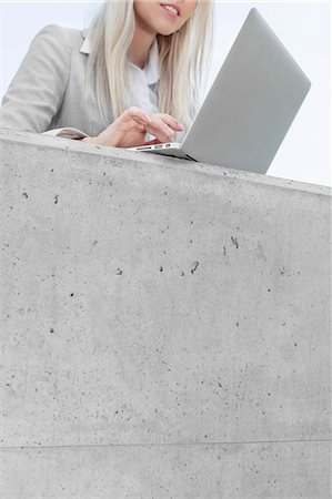 Mid section of young businesswoman using laptop on terrace Stock Photo - Premium Royalty-Free, Code: 693-07444450