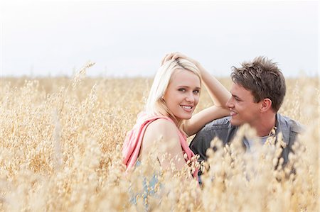 polonia - Portrait of beautiful young woman sitting with boyfriend amidst field Foto de stock - Sin royalties Premium, Código: 693-07444503