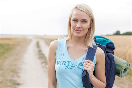 simsearch:693-07672993,k - Portrait of beautiful female hiker with backpack standing on field Foto de stock - Sin royalties Premium, Código: 693-07444514