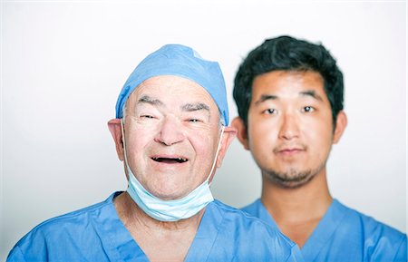 portrait medical white background not animal not smiling - A portrait of Senior adult surgeon and a young Asian doctor Stock Photo - Premium Royalty-Free, Code: 693-07444537