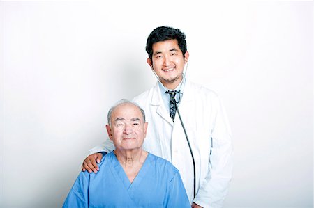 A young Asian Doctor with his hand on the shoulder of a Senior adult patient Photographie de stock - Premium Libres de Droits, Code: 693-07444540