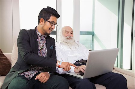 Grandfather and grandson using laptop in living room Stock Photo - Premium Royalty-Free, Code: 693-07455841