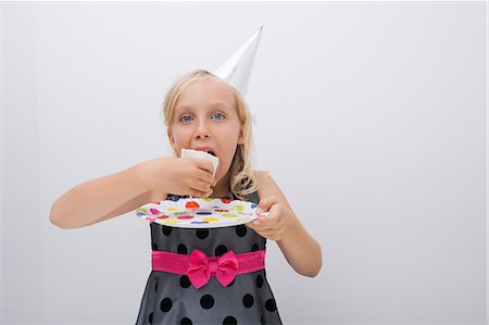 picture of person eating cake - Portrait of cute girl eating birthday cake slice at table in house Stock Photo - Premium Royalty-Free, Code: 693-07455869