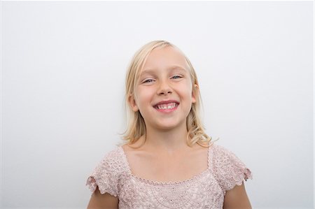 Portrait of girl smiling over white background Stock Photo - Premium Royalty-Free, Code: 693-07455888