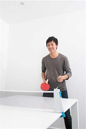 Happy mid adult man playing ping pong Stock Photo - Premium Royalty-Free, Code: 693-07455924