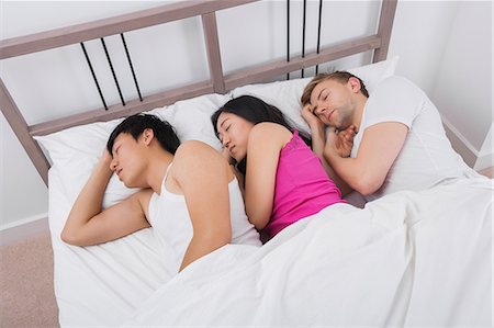 sleeping on bed - Young woman sleeping with two men in bed Foto de stock - Sin royalties Premium, Código: 693-07455950