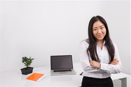 ethnic businesswoman - Portrait of confident businesswoman standing arms crossed in office Stock Photo - Premium Royalty-Free, Code: 693-07455966