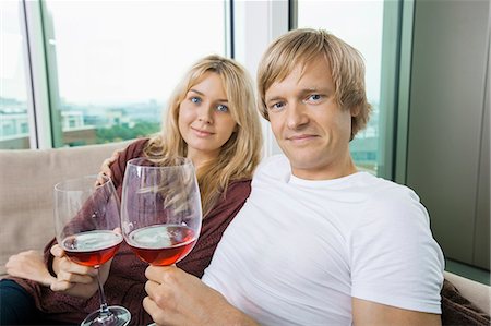 simsearch:693-06379960,k - Portrait of smiling couple with wine glasses in living room at home Stock Photo - Premium Royalty-Free, Code: 693-07456028