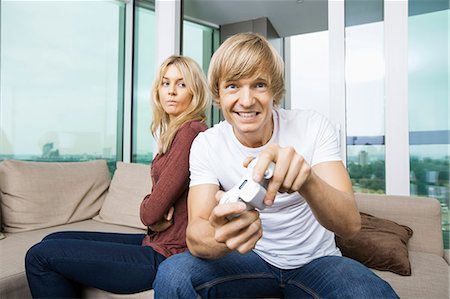 simsearch:693-07456039,k - Angry woman looking at man play video game in living room at home Foto de stock - Sin royalties Premium, Código: 693-07456037