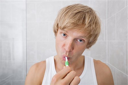 simsearch:693-07456066,k - Portrait of man brushing teeth in bathroom Photographie de stock - Premium Libres de Droits, Code: 693-07456064