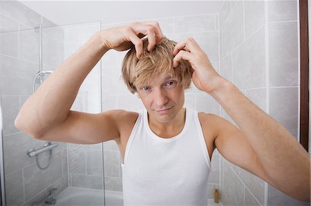 simsearch:693-07456066,k - Portrait of man checking for white hair in bathroom Photographie de stock - Premium Libres de Droits, Code: 693-07456060