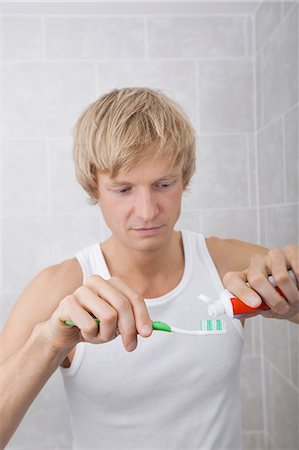 simsearch:693-07456066,k - Man squeezing toothpaste on toothbrush in bathroom Photographie de stock - Premium Libres de Droits, Code: 693-07456063