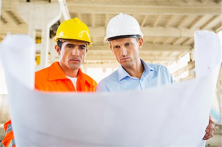 draft (preliminary version) - Male architects reviewing blueprint at construction site Stock Photo - Premium Royalty-Free, Code: 693-07456128
