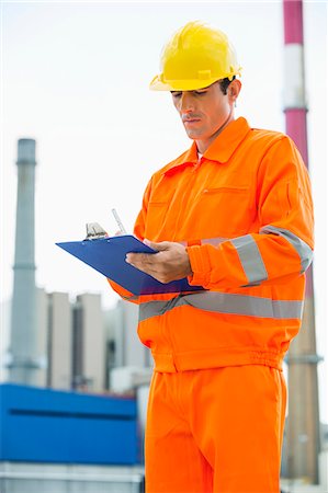 Male architect in protective workwear writing on clipboard at site Stock Photo - Premium Royalty-Free, Code: 693-07456123