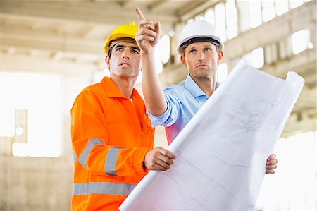 diseñador (hombre y mujer) - Male architects with blueprint working at construction site Foto de stock - Sin royalties Premium, Código: 693-07456131