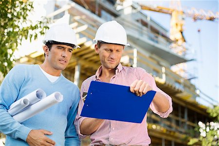 person in crane - Male architects with blueprint and clipboard working at site Stock Photo - Premium Royalty-Free, Code: 693-07456148