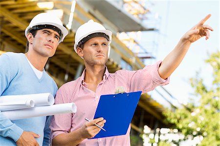 standing engineer - Male architects with blueprint and clipboard working at site Stock Photo - Premium Royalty-Free, Code: 693-07456172