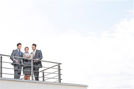 simsearch:693-07672655,k - Businesspeople standing at terrace railings against sky Stock Photo - Premium Royalty-Free, Code: 693-07456195