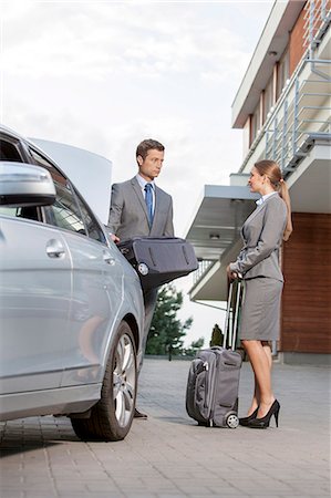 Full-length of business couple with luggage outside hotel Photographie de stock - Premium Libres de Droits, Code: 693-07456209