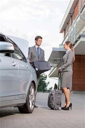 Full-length of business couple with luggage outside hotel Foto de stock - Sin royalties Premium, Código: 693-07456209