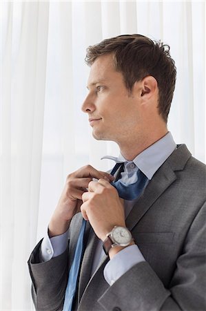 picture men undress - Thoughtful businessman loosening necktie in hotel Stock Photo - Premium Royalty-Free, Code: 693-07456211
